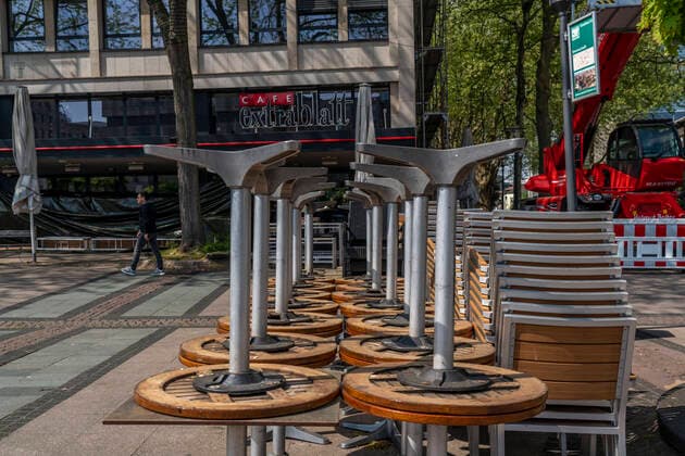 Gestapelte Stühle und Tische von diverses Gastronomie Betrieben, auf dem Kennedyplatz, geschlossene Cafes, Kneipen, Restaurants, Auswirkungen der Coronakrise in Essen, Deutschland,