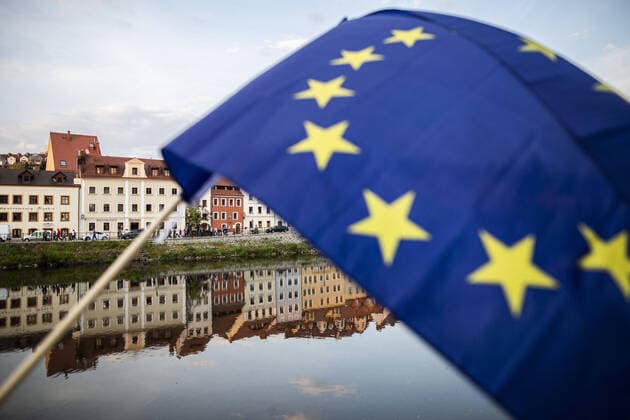 Demonstranten protestieren mit einer EU-Flagge gegen die geschlossene Grenze zwischen Zgorzelec und Goerlitz, 24.04.2020. Zur Eindaemmung des Coronaviruses haben unter anderem Polen und Tschechien Mitte Maerz die Grenzen nach Deutschland geschlossen. Hintergrund des Protestes sind die aktuellen Einschraenkungen fuer Arbeiter, die normalerweise taeglich nach Deutschland pendeln, jetzt aber nach Wiedereinreise nach Polen in zweiwoechige Quarantaene muessten. Ausserdem sind grenzuebergreifende, familiaere Kontakte durch die geschlossenen Grenzen schwer moeglich. Goerlitz Deutschland