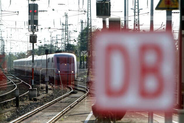 Einfahrender ICE der DB Deutsche n Bahn hinter einer Scheibe mit Unternehmenslogo im Hauptbahnhof Karlsruhe, Baden Württemberg, Deutschland