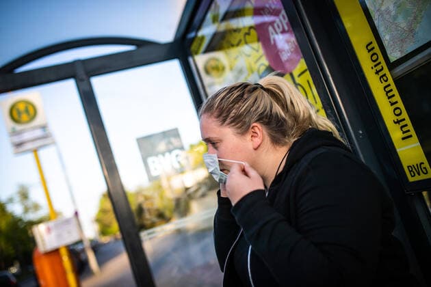 News Bilder des Tages Ein Frau legt eine Mund-Nasen-Maske an einer Bushaltestelle der BVG in Berlin an. Ab Montag, den 27. April 2020 gilt eine Maskenpflicht im ÖPNV. Maskenpflicht im ÖPNV