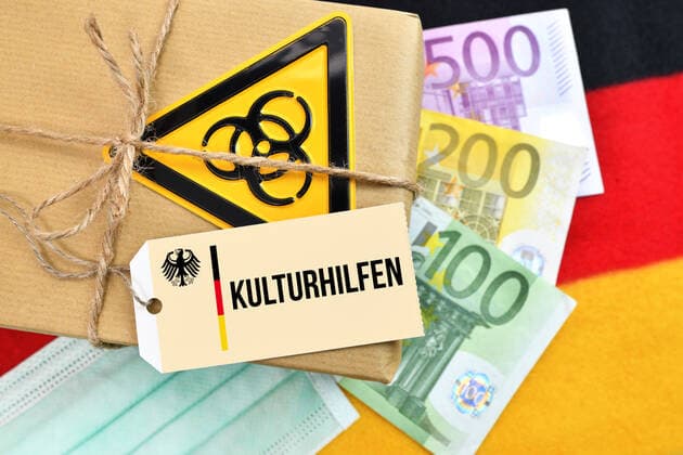 FOTOMONTAGE, Paket mit BiogefÃ¤hrdungszeichen auf Deutschlandfahne mit Etikett und der Aufschrift Kulturhilfen