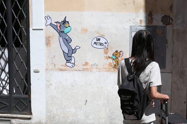 Mauro Pallotta, aka Maupal, created a new mural in Borgo Pio, a few meters from the Vatican and St. Peter s square. The work depicts the characters of the cartoon Tom & Jerry. Both Tom, the cat, and Jerry, the mouse, wear a mask. Jerry, who is usually chased by Tom, scolds the other and tells him to respect the safety distance, one meter, in the photo a boy takes the mural with the i-pod (Alberto Lo Bianco Fotogramma, Rome - 2020-04-30) p.s. la foto e utilizzabile nel rispetto del contesto in cui e stata scattata, e senza intento diffamatorio del decoro delle persone rappresentate Copyright: xAlbertoxLoxBiancox xFOTOGRAMMAx