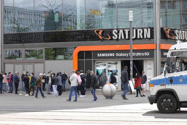 Waehrend der Corona-Krise, bildet sich am Samstagmittag vor dem Saturnmarkt auf dem Alexanderplatz, eine Menschenmenge die im Saturn einkaufen moechte, DEU, Berlin, 02.05.2020