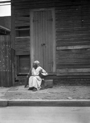 Female Praline Vendor sitting on Steps holding a Basket, New Orleans, Louisiana, USA, Arnold Genthe, 1920 s  Copyright: xCircaxImagesx ghi-circa08066