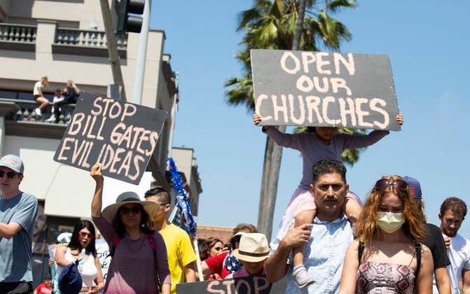 May 1, 2020, Huntington Beach, California, USA: A STOP BILL GATES EVIL IDEAS and OPEN OUR CHURCHES signs displayed, as part of thousands of people gather at the corner of Main Street and Pacific Coast Highway to protest coronavirus (COVID-19) Protesters are unhappy about California s stay-at- home measures and Governor s closing Orange County beaches in particular. Mounted police on horseback line up in force at entrance to beach and Huntington Beach Pier. Huntington Beach U.S. - ZUMAk136 20200501_int_k136_280 Copyright: xKatrinaxKochnevax
