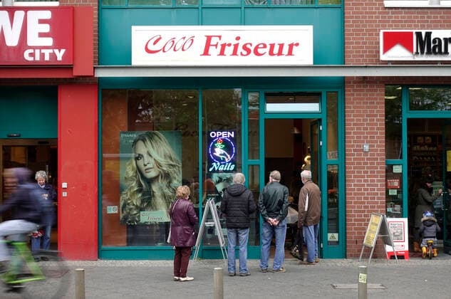 Am ersten Tag nach der Wiedereroeffnung der Friseursalons, stehen Menschen vor einem Friseurgeschaeft, waehrend der Corona-Krise, an, DEU, Berlin, 04.05.2020