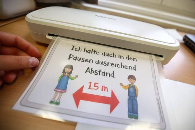 04.05.2020, xcex, GER, Darmstadt, Hessen, Corona, Schliessung, Krise, Symbolbild, Symbofoto Coronavirus, Corona-Epedemie, wegen des Coronavirus sind die Schulen geschlossen, Vorbereitung auf Wiedereroeffnung, Schulalltag Corona-Schliessung Hinweisschild fuer die Schueler, laminiert, Laminiergeraet, Abstand in der Pause