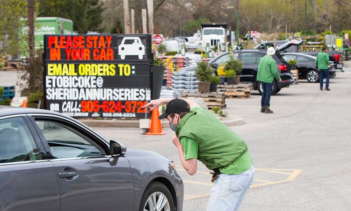 (200504) -- TORONTO, May 4, 2020 -- A staff member directs a car at the entrance of a garden center in Toronto, Canada, on May 4, 2020. Some provinces in Canada on Monday started easing some of their COVID-19 restrictions following a weekend over which thousands more cases were identified and hundreds more deaths reported. (Photo by Xinhua) CANADA-TORONTO-COVID-19-SEASONAL BUSINESSES-REOPENING ZouxZheng 