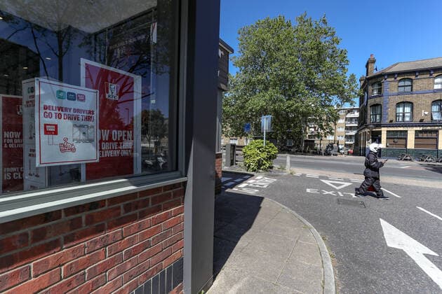 KFC has decided to reopen most of its branches across the UK for takeaway orders only, although its branch in Old Kent Road is seen deserted, the drive-through branch in Deptford Evelyn Street in London, is seen taking orders through delivery services such as Uber, Deliveroo and Stewart on Tuesday, May 5, 2020.(Photo Vudi Xhymshiti)  VXP
