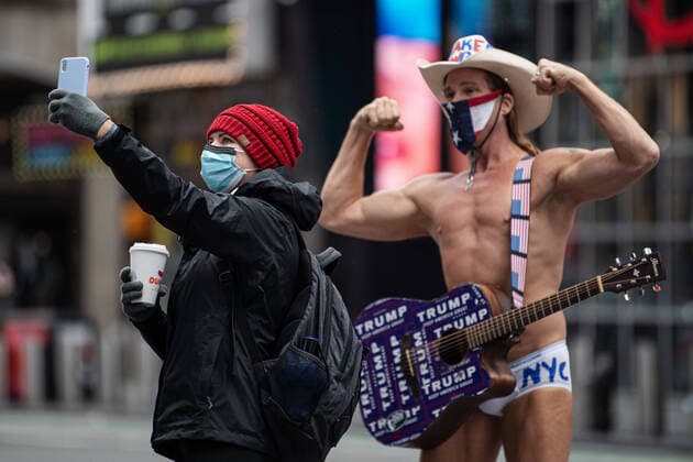 200506 A woman takes a selfie with street performer Robert John Burck, known as Naked Cowboy, at Times Square in Manhattan as the coronavirus, COVID-19, outbreak continues on May 6, 2020 in New York, NY, USA. Photo: Joel Marklund BILDBYRAN kod JM 88150 bbeng coronavirus covid-19 virus corona sjukdom artist Copyright: JOELxMARKLUND 0047240876st