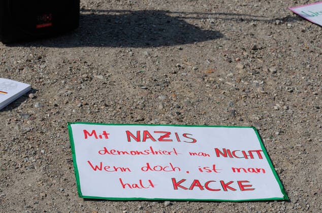 Coronavirus, Demonstration gegen Corona-Maßnahmen Transparent auf Sandboden und Aufschrift Mit Nazis demonstriert man nicht. Wenn doch, ist man halt Kacke , am 09.05.2020 in Flensburg, Hafen, Hafenspitze