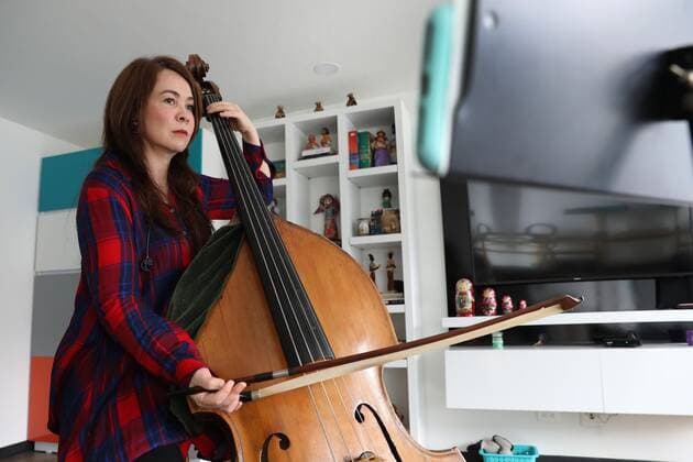 Photograph dated May 9, 2020 in which the bassist of the Bogota Philharmonic Orchestra Monica Suarez is seen while playing her instrument and recorded with her mobile phone in the living room of her apartment in Bogota, Colombia 10 May 2020. In these days of pandemic and confinement, the musicians of the Bogota Philharmonic Orchestra have taken advantage of technology and social networks to express their art and present themselves to an audience that cannot be crowded to see them live and direct. The COVID-19 changes the score to the musicians of the Bogota Philharmonic !ACHTUNG: NUR REDAKTIONELLE NUTZUNG!  Copyright: xCarlosxOrtegax AME8908 20200510-637247324514667897