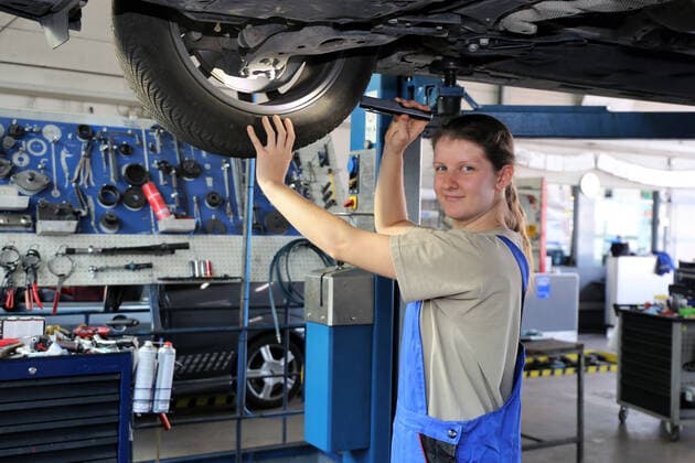 Symbolbild: Frau in Männerberuf: KfZ-Mechatronikerin (Model released) *** symbolic picture of a woman in a mans profession car mechatronics model released