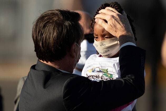 Brazilian President Jair Bolsonaro interacts with a girl while participating in a National flag raising ceremony in front of the Alvorada Palace, in Brasilia, Brazil, 12 May 2020. Brazil already has 11,519 deaths from COVID-19, while the number of infected exceeds 168,300 people, the Ministry of Health reported. Dressed in masks, Bolsonaro and his ministers participate in official act in Brasilia !ACHTUNG: NUR REDAKTIONELLE NUTZUNG!  Copyright: xJoedsonxAlvesx AME9220 20200512-637248958474838554