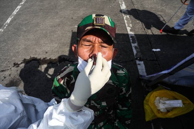 Bilder des Jahres 2020, News 05 Mai News Bilder des Tages May 13, 2020, Bandung, West Java, Indonesia: A health worker wears personal protective clothing while doing a test swab against a soldier during a coronavirus disease (COVID-19) in the Terminal. The test swab was executed randomly in several terminals to map more broadly the Covid-19 spread. Bandung Indonesia - ZUMAf147 20200513_zip_f147_003 Copyright: xAgvixFirdausx
