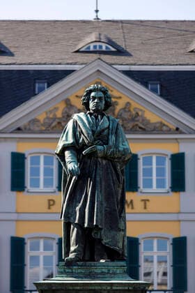 Beethoven-Statue von Ernst Hähnel und Jacob Daniel Burgschmiet auf dem Münsterplatz mit ehemaligem Hauptpostamt. Das Programm zum Beethoven-Jahr wird wegen der Coronakrise bis 2021 verlängert. Bonn, 12.05.2020