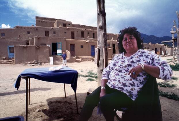 IMAGO Cultures of the world, Taos Pueblo in New Mexico, USA 1 Reisen: Indianierin verkauft selbst gebackenes im Taos Pueblo in New Mexico, erdfarbener Adobe Baustil (Stroh, Erde & Wasser), ca. 150 Menschen wohnen dort dauerhaft, Ureinwohner Nordamerikas, Holz, Holzstäbe, Bohlen, Indian Nation, Reise, Attraktion, Sehenswürdigkeit, Urlaub, Tourismus, bekannte Touristengegend, Touristenort, Urlaubsort, Touristenattraktion, Reiseziel, Urlaubsziel, Sehenswürdigkeit, Indianerkind, Kind, Junge, Natives, Amerika, Kult, Sitte, Kultur, Kultstätte, Taos Pueblo New Mexico United States Of America Copyright: xBriganiArt ArtistxAtxWork Heinrix 00024053_00024053