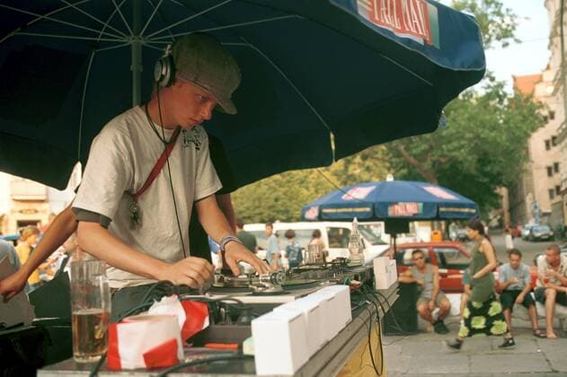 27 Fete de la Musique: DJ vor der Berliner Bar H2O, Corpus Delictee Flex, Open Air, Freilicht, Musikfest, Straßenfest, Party, umsonst, auf der Straße, Berliner Kultur, Zuschauer, Publikum, sitzen, Musik, Sommer, auflegen, Berlin Deutschland, Germany *** 27 Fete de la Musique DJ in front of the Berlin Bar H2O, Corpus Delictee Flex, open air, open air, music festival, street party, party, for free, on the street, Berlin culture, spectators, audience, sitting, music, summer, djing, Berlin Germany, Germany Copyright: xPOP-EYE Morlokx 00026853_00026853