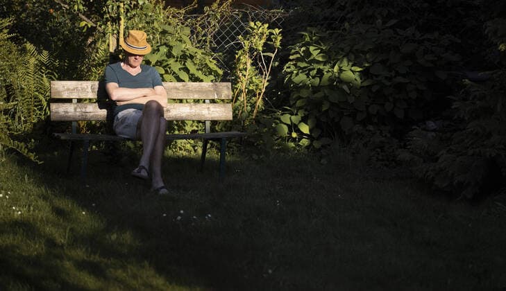 Ein Mann mit Strohhut sitzt alleine auf einer Bank in seinem Garten, Bonn, 17.05.2020. Bonn Deutschland