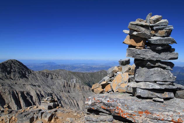 Berg Olymp Der Olymp ist die höchste Gebirgskette Griechenlands. Das Massiv befindet sich an der Ostküste Griechenlands auf der Grenzlinie zwischen Makedonien und Thessalien, nahe der Stadt Katerini und dem Ort Litochoro. In der Mythologie ist der Berg Olymp der Sitz der olympischen Götter, der Abkömmlinge und Diener der Götter. Der Gebirgsstock ist seit 1938 unter Naturschutz und seit 1981 UNESCO Biosphärenreservat. Im Bild: Steinmännchen am Mytikas-Gipfel (2918 Meter) des Olymp und Blick auf die Nordwand des Skolio. Olymp Zentralmakedonien Griechenland-Greece