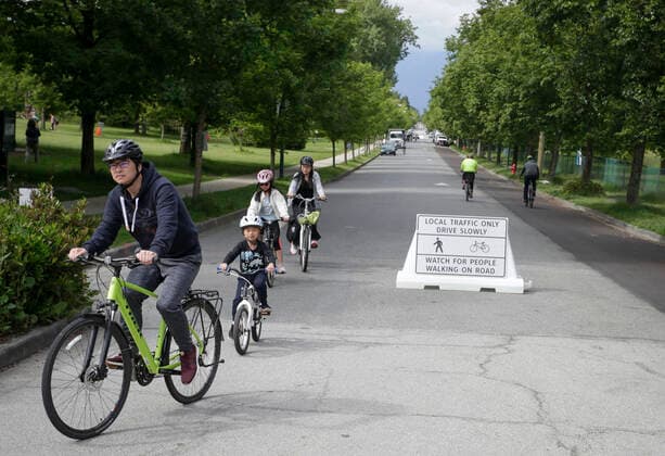 (200525) -- VANCOUVER, May 25, 2020 (Xinhua) -- People cycle on the Slow Street at a road in Vancouver, Canada, May 24, 2020. City of Vancouver unveiled the Slow Streets program allowing people to walk and bike on the roads with limited local traffic in order to provide more space to the people to maintain physical distance. (Photo by Liang Sen Xinhua) CANADA-VANCOUVER-COVID-19-SLOW STREETS 