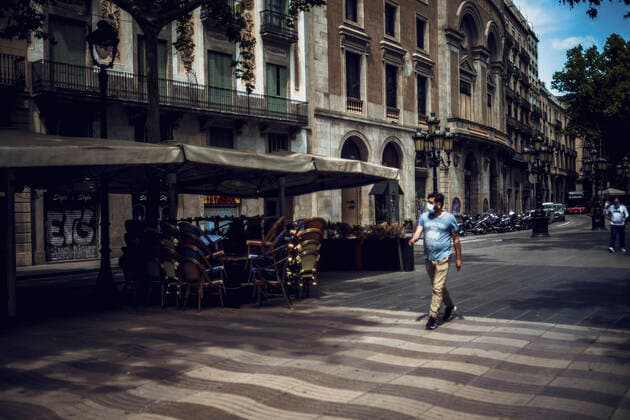 May 25, 2020: A commuter passes a closed terrace bar at the Rambla as Barcelona enters the second phase of a gradual way to the new normal rolling back a nearly seven weeks long nationwide strict lockdown due to the spread of the corona virus. Today Barcelona enters the second of four phases as one of the last territories permitting the restricted reopening of hotels, museums, libraries, shops and bar terraces among other measures of ease. - ZUMAo105 20200525_zap_o105_014 Copyright: xMatthiasxOesterlex