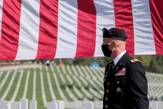 USA, Memorial Day in Zeiten des Coronavirus May 25, 2020, Los Angeles, California, U.S: A US Army soldier wearing a face mask walks by a U.S. flag at the Los Angeles National Cemetery to honor fallen soldiers and health care workers in Los Angeles, Monday, May 25, 2020. The annual Memorial Day commemoration at the cemetery was held without the public in attendance due to the coronavirus outbreak. Los Angeles U.S. - ZUMAc68_ 20200525_zaf_c68_022 Copyright: xRingoxChiux