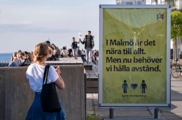 People enjoy the warm evening at Sundspromenaden in Malmo, Sweden, on May 26, 2020 The sign reads In Malmo everything is near But now we need to keep a distance MALMÖ SWEDEN x50090x,  Copyright: xJohanxNilsson TTx SWEDEN DAILY LIFE WEATHER CORONA