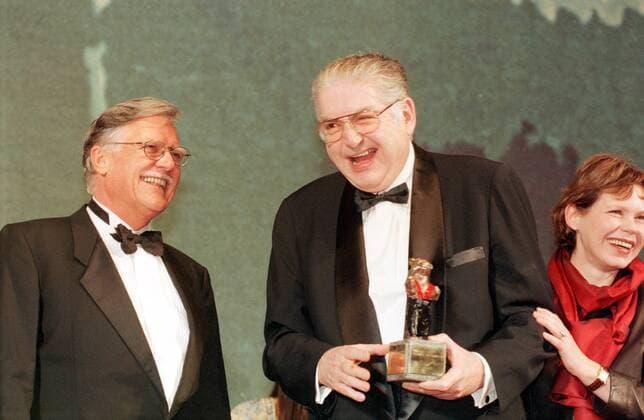1 Berlinale 99: Festivalleiter Moritz de Hadeln bekommt einen Hosenträgerbär von Michael Ballhaus & Renate Krössner, als Preis für 20 Jahre Festivalleitung, ein silberner Hosenträger-Bär, wegen de Hadelns Vorliebe für dieses Bekleidungsstück, Spassbär, Spaßbär, Spaß, glücklicher Gewinner, zeigt Stolz seinen Bär mit Hosenträgern, glücklich, Freude, Jubel, Schauspielerin in Film, Fernsehen, TV, Serien, Abschlußveranstaltung der INTERNATIONALEN FILMFESTSPIELE in Berlin, internationale, Filmfest, Kino, Prominente, Promi, Gesellschaft, Preis, Filmfestival, deutscher Kameramann in Hollywood, Berlin Germany *** 1 Berlinale 99 Festival Director Moritz de Hadeln receives a Suspender Bear from Michael Ballhaus Renate Krössner, as a prize for 20 y Copyright: xBRIGANI-ART HEINRICHx 00018136_00018136