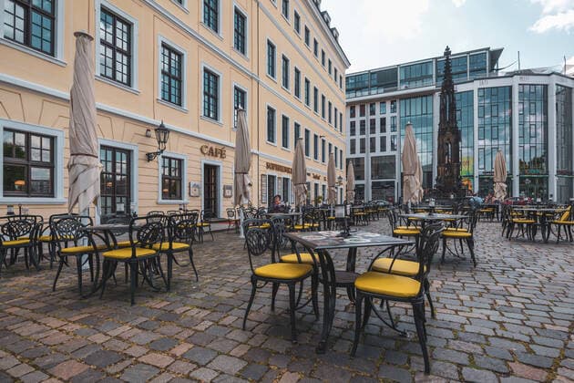 Überwiegend leere Tische auf der Terrasse vor dem Cafe Apotheke und dem Restaurant Sophienkeller in der Innenstadt von Dresden
