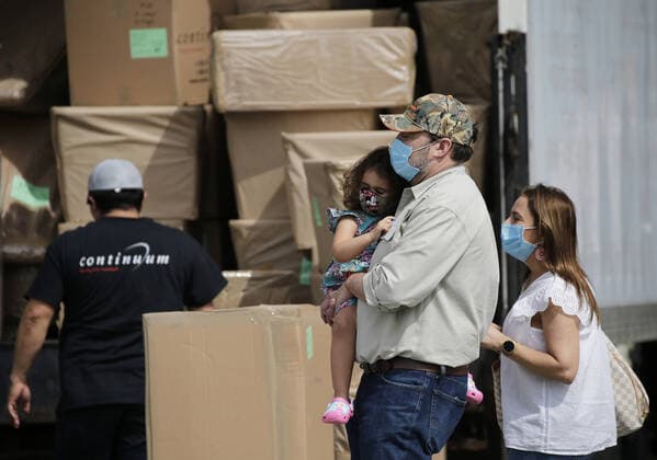 A man, woman and child wearing protective face masks walk by a moving company worker and truck in the days of the Coronavirus Pandemic in New York City on Wednesday, May 27, 2020. New Yorkers cannot be evicted for failing to pay their rent amid the coronavirus crisis. Gov. Andrew M. Cuomo recently announced a 60-day extension through August 20 of a moratorium that was scheduled to end in June. More than 5.5 million cases of COVID-19 have been reported worldwide resulting in over 345,000 deaths.  NYP20200527101 JOHNxANGELILLO