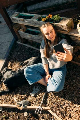 Happy young woman with dog in garden taking a selfie model released Symbolfoto property released GUSF03570