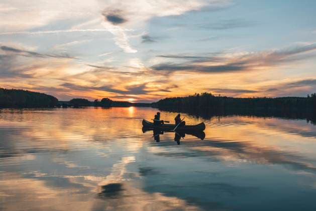 Young people boating on lake at sunset model released Symbolfoto GUSF03747