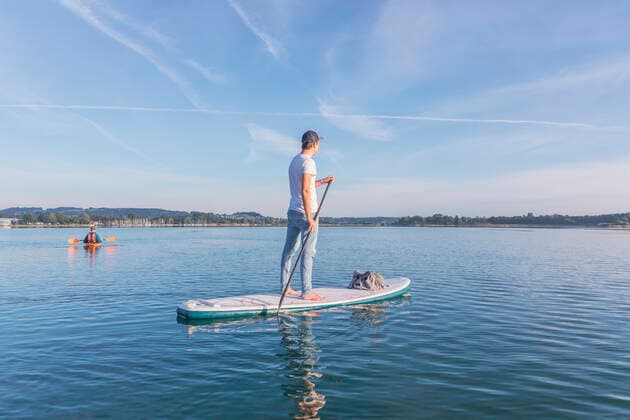 Man standing on sup board on a lake model released Symbolfoto MMAF01303
