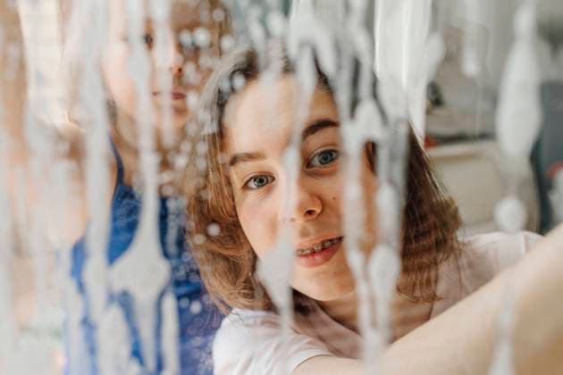 Portrait of teenage girl looking through wet windowpane model released Symbolfoto property released OGF00305