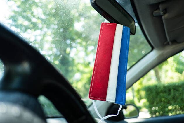 Eine selbstgenähte Atemschutzmaske mit den Farben der niederländischen Flagge hängt im Auto an einem Rückspiegel düsseldorf Nordrhein-Westfalen Deutschland