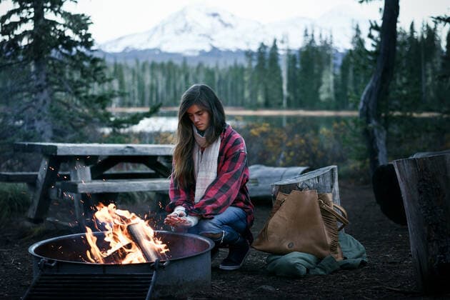 Young Woman crouching by fire warming hands Sisters, OR, United States CR_ADMC200413-359414-01,model released, Symbolfoto