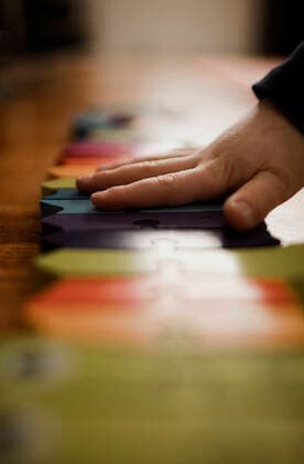IMAGO Creative: Jahreszeit Winter, Fantasievoll drinnen spielen Preschooler boy s hand putting together a brightly colored puzzle Calgary, AB, Canada CR_AMST200428-362096-01,model released, Symbolfoto ,property released