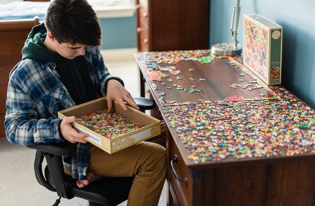 Teen boy working on a jigsaw puzzle in his bedroom during Covid 19. Kingston, ON, Canada CR_DOHO200406-348764-01,model released, Symbolfoto