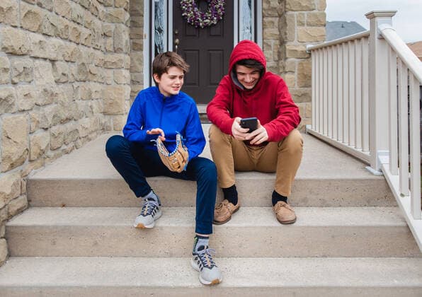 IMAGO Kreativ: Bruderschaft Two teenage boys sitting and talking on the front steps of a house. Kingston, ON, Canada CR_DOHO200506A-385950-01,model released, Symbolfoto