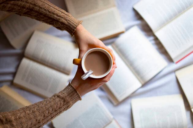 Hand picking up a cup of warm coffee with books. Barcelona, CT, Spain CR_EAFU200424B-353344-01,model released, Symbolfoto