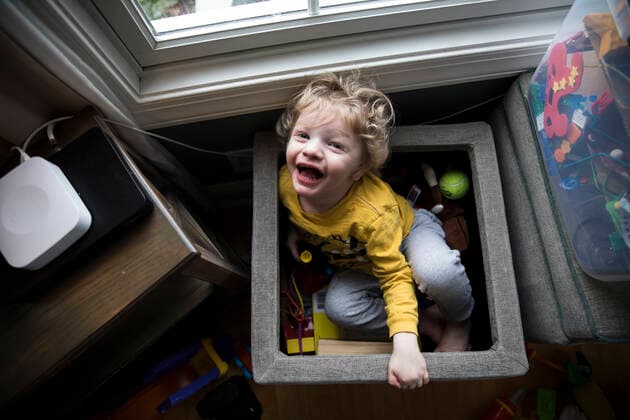 IMAGO Creative: Jahreszeit Winter, Fantasievoll drinnen spielen Laughing Boy Sits in Toy Box Next to Storage Bins Looks Up at Camera Easton, MD, United States CR_EMJA200506A-357579-01,model released, Symbolfoto