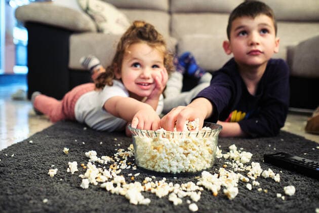 IMAGO Creative, Weihnachten, Tradition: Weihnachtsfilme sehen siblings watching a home movie while eating popcorn Seville, AL, Spain CR_FAGU200508-363123-01,model released, Symbolfoto