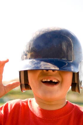 Portrait of young boy missing a tooth with baseball helmet pulled down over his eyes San Diego, CA, United States CR_FRRO200407C-261363-01,model released, Symbolfoto