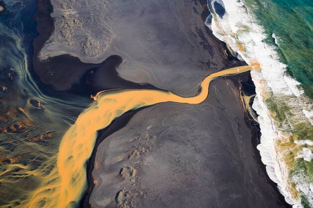 Aerial view of braided orange river flowing into ocean in southe Reykjavík, Iceland CR_ISKO200331A-260043-01