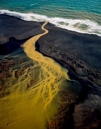 IMAGO Creative: Kraft des Wassers Aerial view of braided orange river flowing into ocean in southe Reykjavík, Iceland CR_ISKO200331A-260168-01