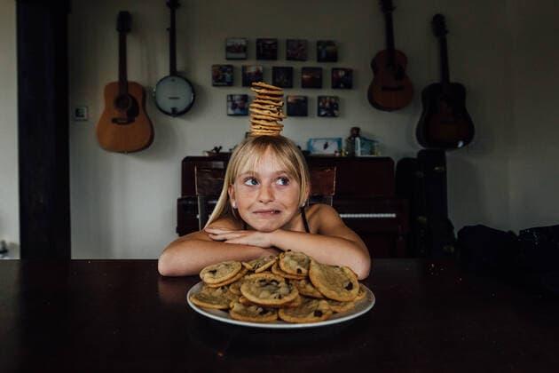 IMAGO Creative: Jahreszeit Winter, Fantasievoll drinnen spielen Young girl balancing cookies on her head Windsor, ON, Canada CR_JEOH200518-377581-01,model released, Symbolfoto