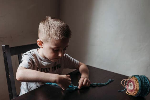 IMAGO Creative: Digitale Welt, Verzicht auf Technologie Young boy knitting with fingers at home during isolation San Diego, CA, United States CR_KESM200409-341162-01,model released, Symbolfoto