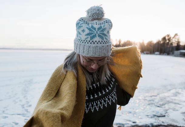 IMAGO Creative: Wintersport, Mode portrait of woman holding scarf whilst walking on a frozen lake Bjuraker, Gavleborg County, Sweden CR_RABE200406B-336151-01,model released, Symbolfoto