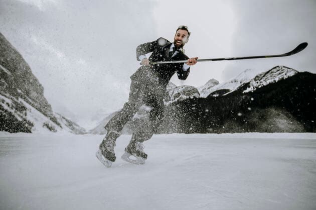 IMAGO Creative, Jahreszeit Winter, Eislaufen smiling hockey player wearing suit stops fast on frozen Lake Louise Lake Louise, AB, Canada CR_SSNF200422A-341530-01,model released, Symbolfoto